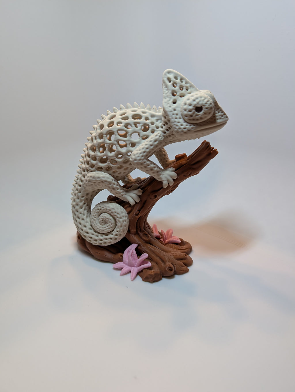Chamäleon-Figur auf einem Baumstück