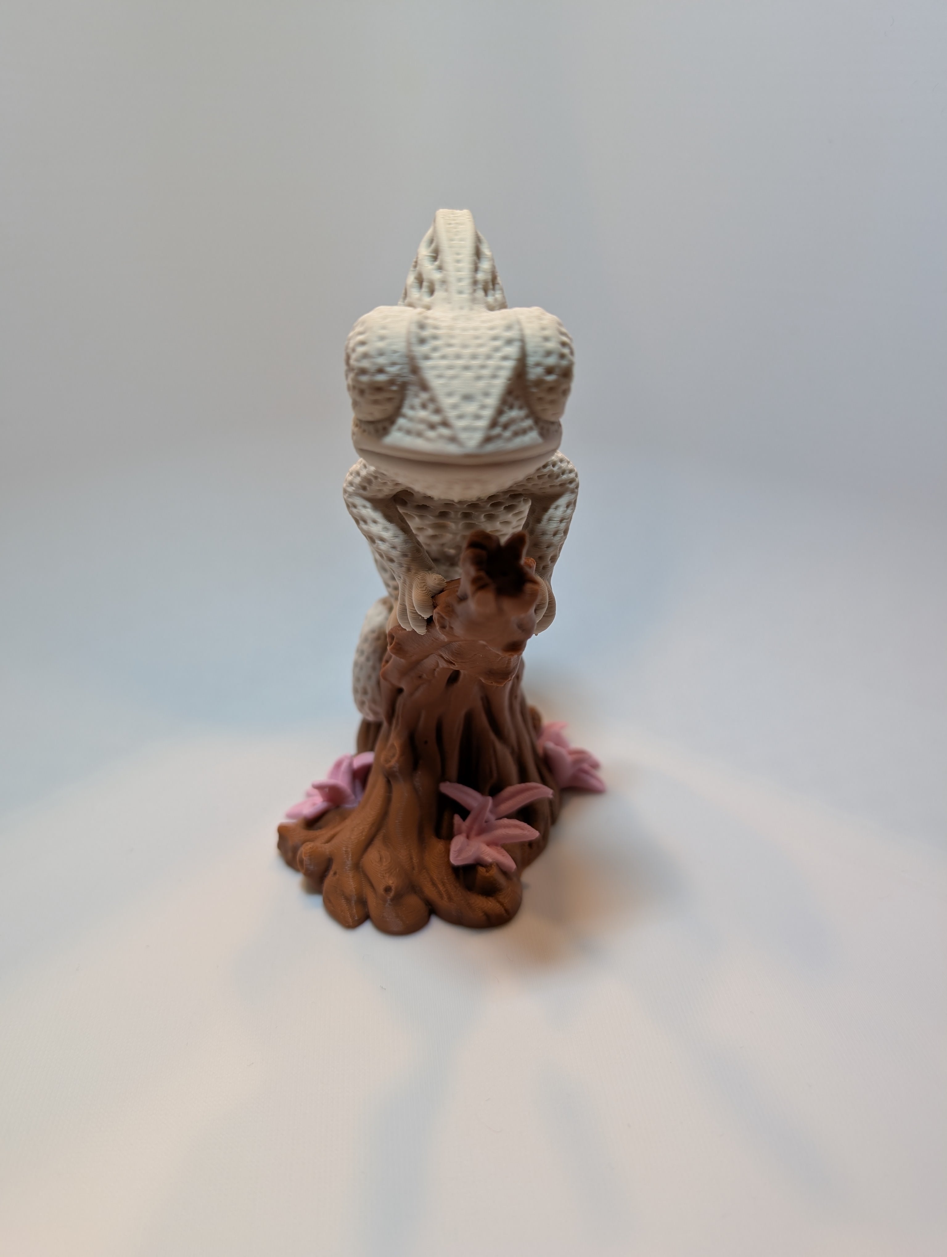 Chamäleon-Figur auf einem Baumstück