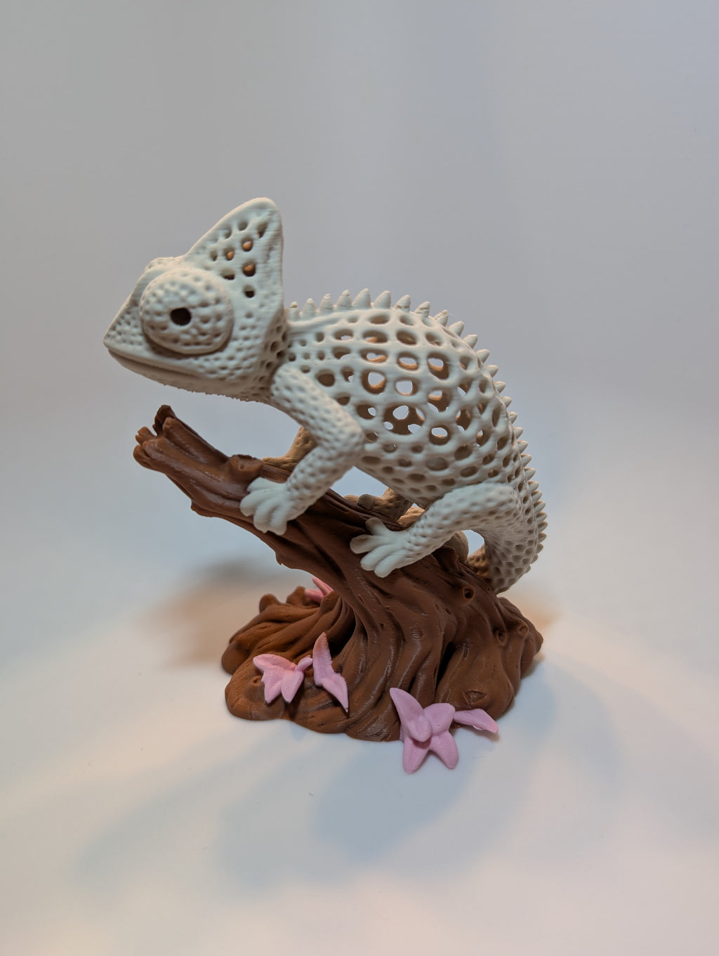 Chamäleon-Figur auf einem Baumstück